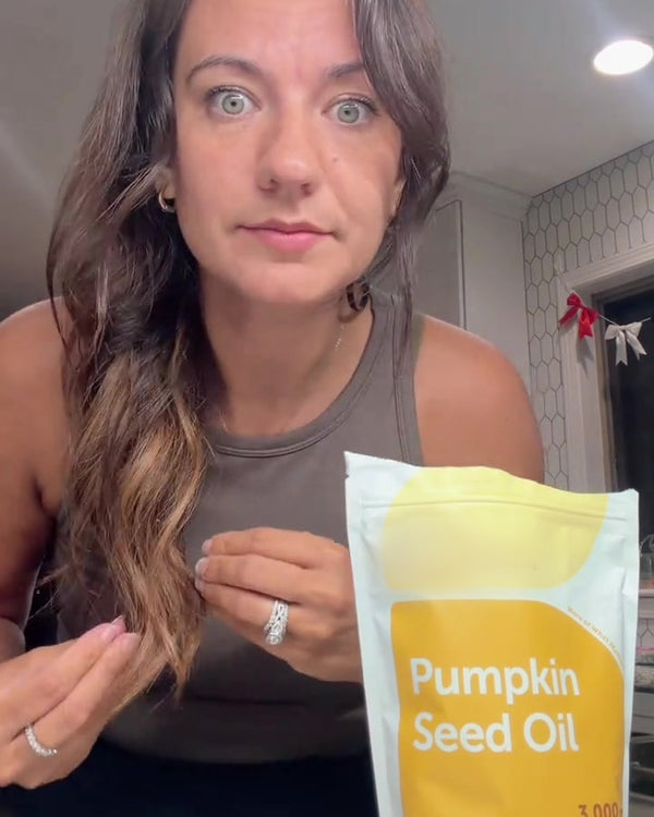Customer holding the yellow Pumpkin Seed Oil pouch to camera