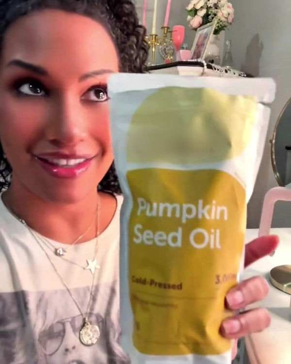 Customer presenting the yellow Pumpkin Seed Oil pouch with both hands