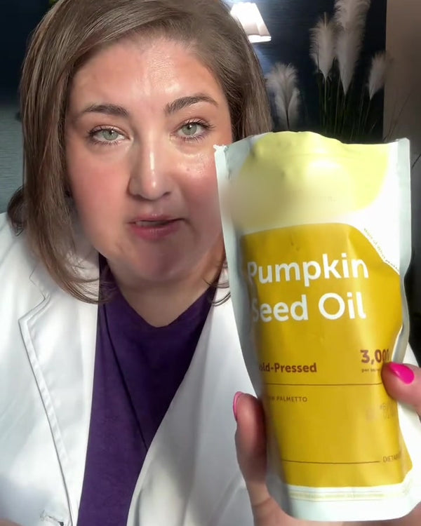 Customer holding the yellow Pumpkin Seed Oil pouch, face to camera