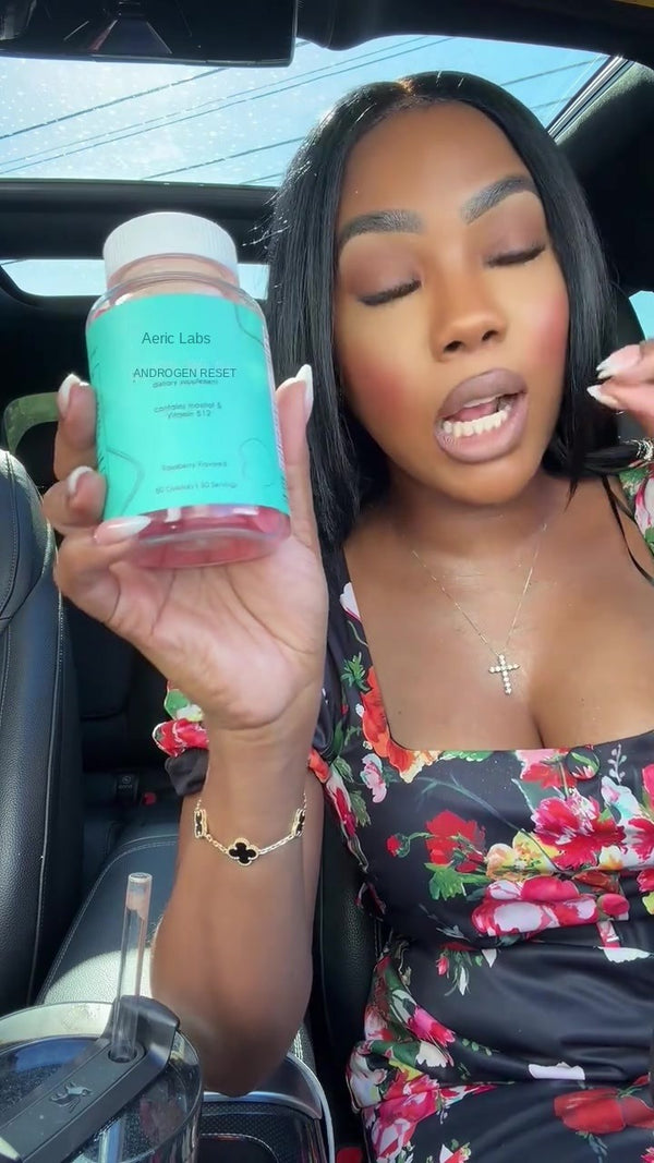 Customer holding The Androgen Reset to camera