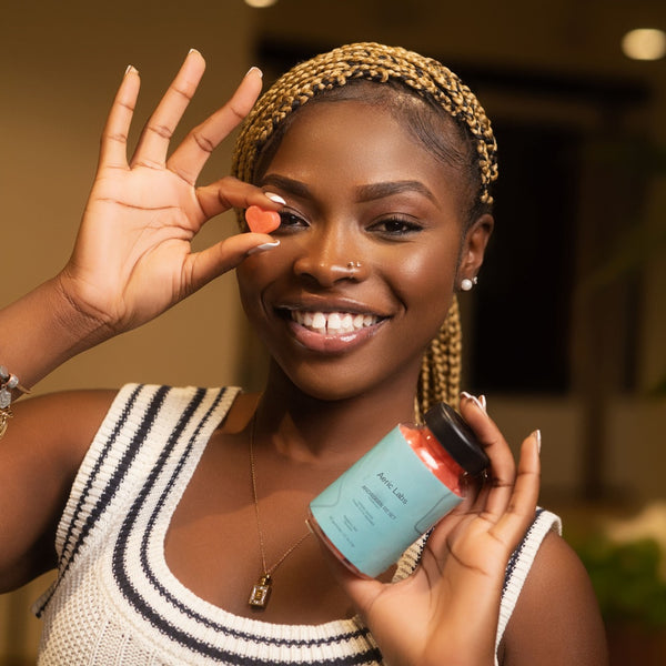 Customer holding a raspberry mint heart gummy and a bottle of The Androgen Reset